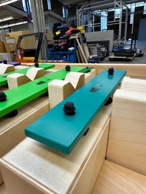 Nahaufnahme einiger bunter Klangplatten aus Metall von einem Klangxylophon.