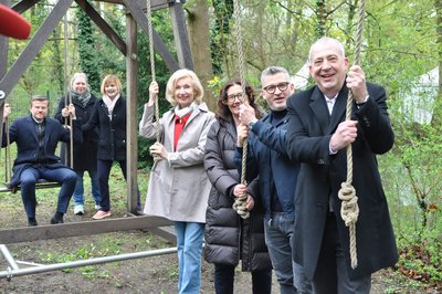 Gruppenfoto von sieben Personen auf dem Erfahrungsfeld. Nürnbergs Oberbürgermeister Marcus König sitzt auf einer Schaukel, daneben steht die Vorsitzende des Fördervereins Silke Hacker. Daneben Jana Stadlbauer, die Leiterin des Erfahrungsfeldes. Dann Julia Lehner, die ehemalige Kulturbürgermeisterin von Nürnberg. Neben ihr steht Annekatrin Fries, Leiterin des Nürnberger Amtes für Kultur und Freizeit. Daneben zwei Sponsorenvertreter: Heiko Linder von der N-Ergie und Stefan Schindler von der Sparda Bank Nürnberg.